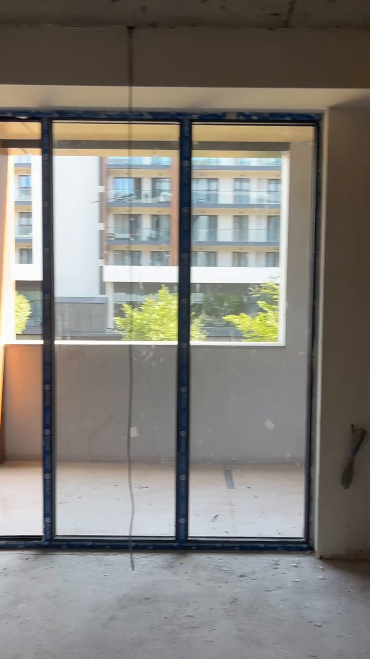 Full-height balcony door and window unit, protective film still on the frames