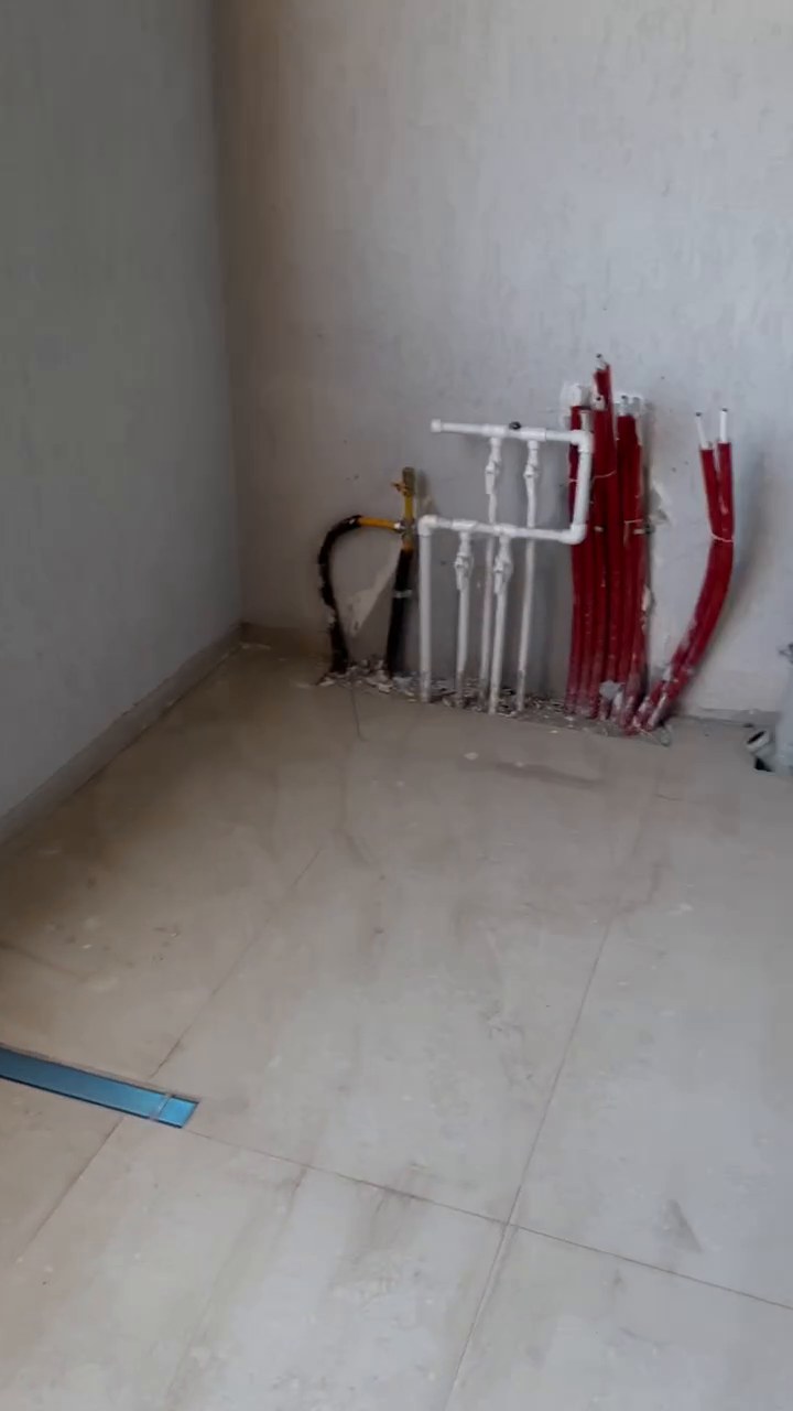 Balcony corner with gas pipe, white water manifold with valves and red PEX distribution