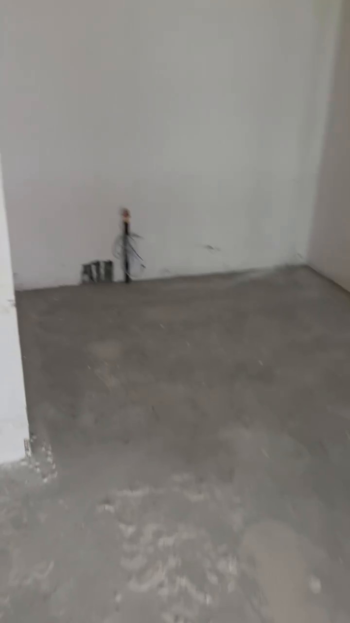 Wet room shell with a drain stack and pipe stubs in the corner